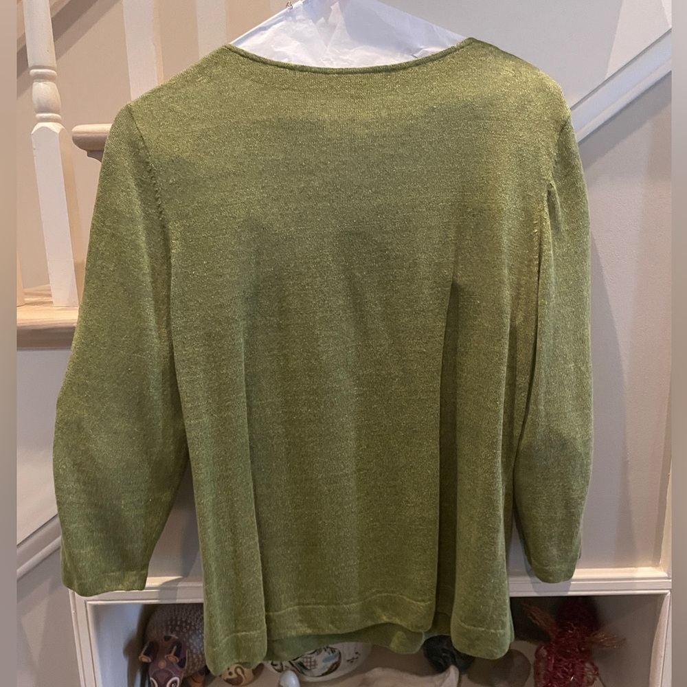 Color is moss green with dark flecks.  This is a 100% linen sweater.